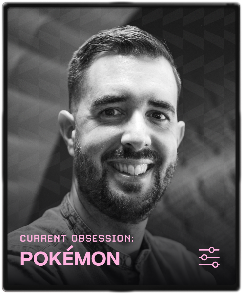 Portrait of a man with brown hair and glasses on a flat gray background.